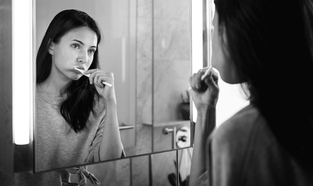 Vrouw poetst haar tanden in de ochtend