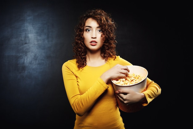 Vrouw popcorn eten tijdens het kijken naar film kijken op road show