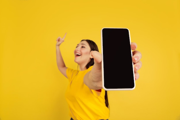 Vrouw portret geïsoleerd op gele studio muur