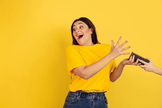 Vrouw portret geïsoleerd op gele studio muur