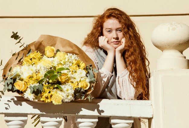 Vrouw poseren buitenshuis met boeket van Lentebloemen