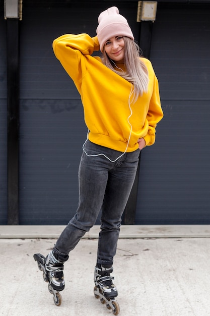 Gratis foto vrouw poseren in muts met rolschaatsen