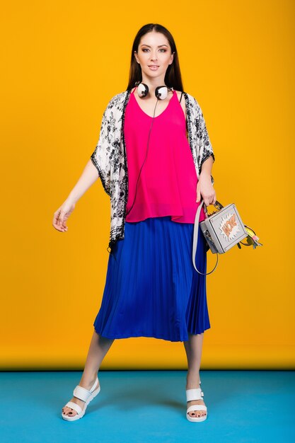 Vrouw poseren in stijlvolle zomer mode en kleurrijke sfeer tas