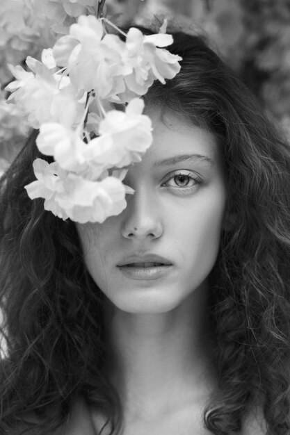Vrouw poseren met bloemen zwart-wit vooraanzicht