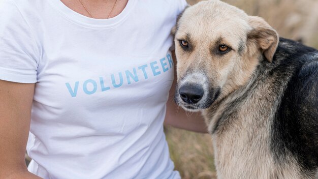 Vrouw poseren met schattige maar droevige hond buitenshuis