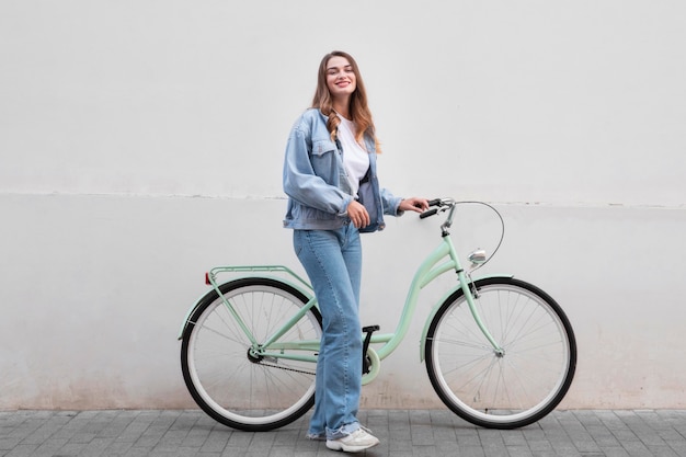 Vrouw poseren terwijl haar fiets buiten in de stad