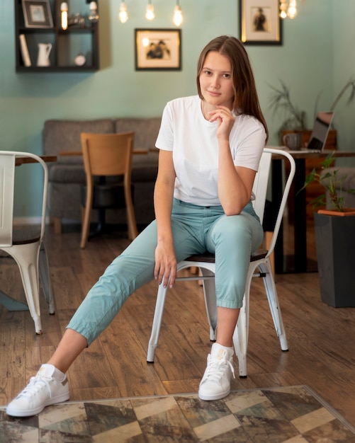 Gratis foto vrouw poseren thuis op stoel tijdens de pandemie