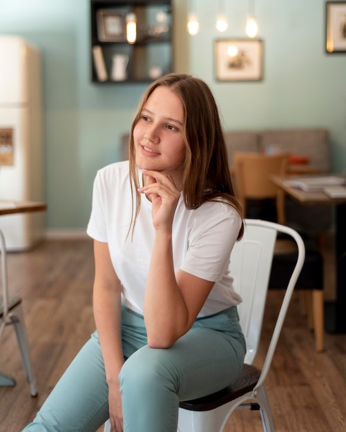 Gratis foto vrouw poseren thuis op stoel tijdens quarantaine