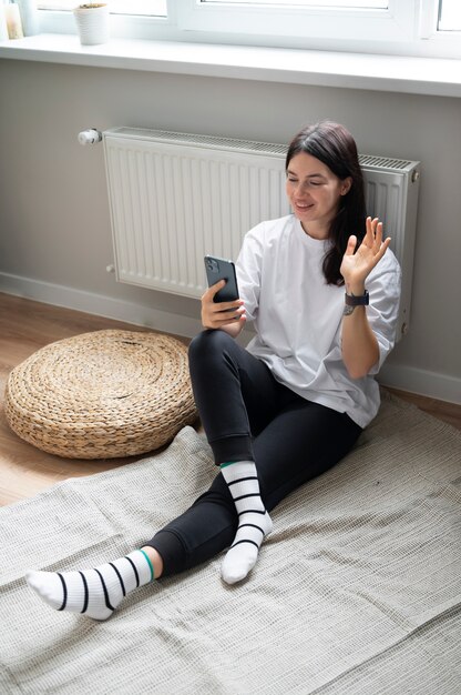 Vrouw praat thuis op haar smartphone tijdens quarantaine