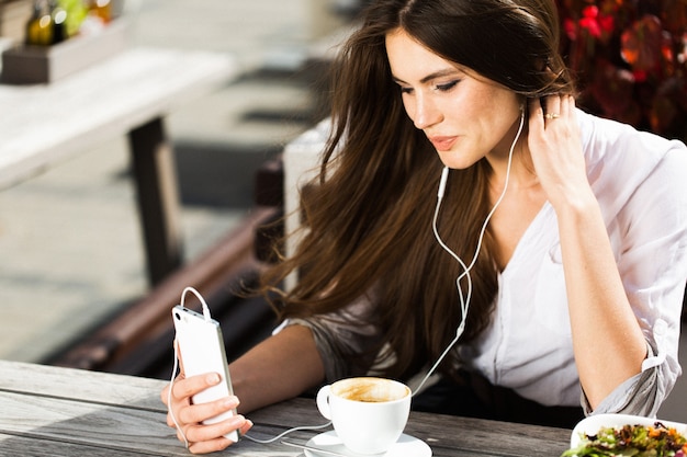 Vrouw praat via de koptelefoon aan de telefoon