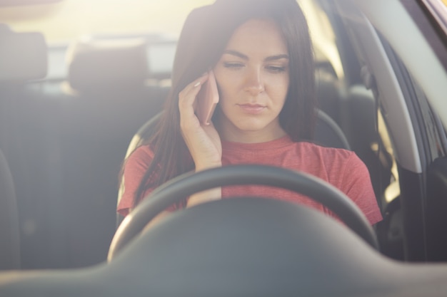 Vrouw praat via mobiele telefoon met echtgenoot, weet niet wat te doen als stopt onderweg, heeft geen benzine in auto