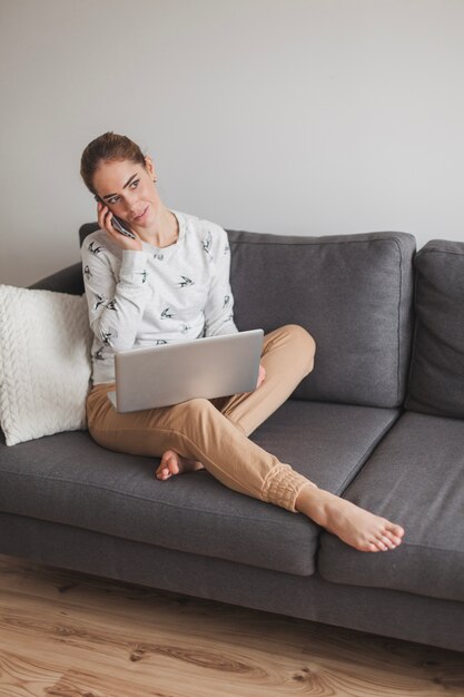 Vrouw praten over de telefoon op sofá