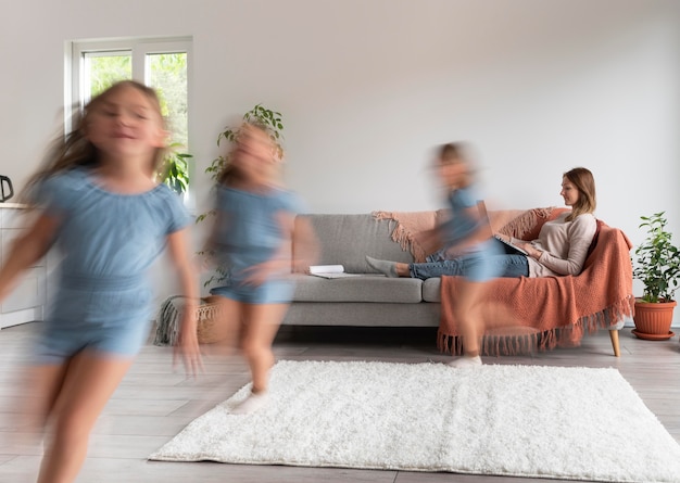 Vrouw probeert thuis op laptop te werken terwijl haar kinderen rondrennen