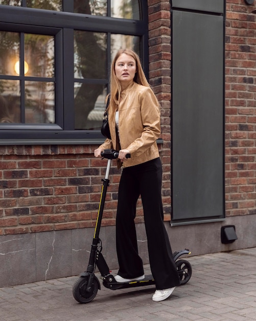 Vrouw rijden elektrische scooter buitenshuis