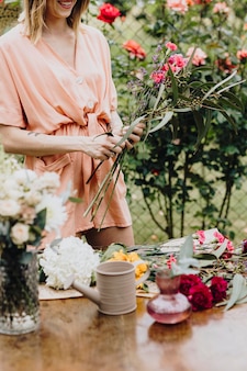 Vrouw schikt bloemen in een tuin