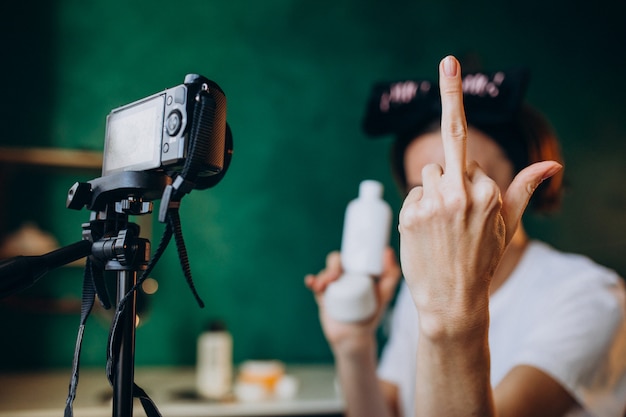 Vrouw schoonheid blogger filmong nieuwe vlog en middelvinger tonen in de camera