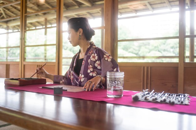 Vrouw schrijft met inkt op Japans papier