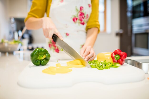 Vrouw snijden groenten op snijplank
