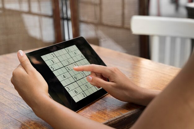 Vrouw speelt een sudoku-spel op haar tablet