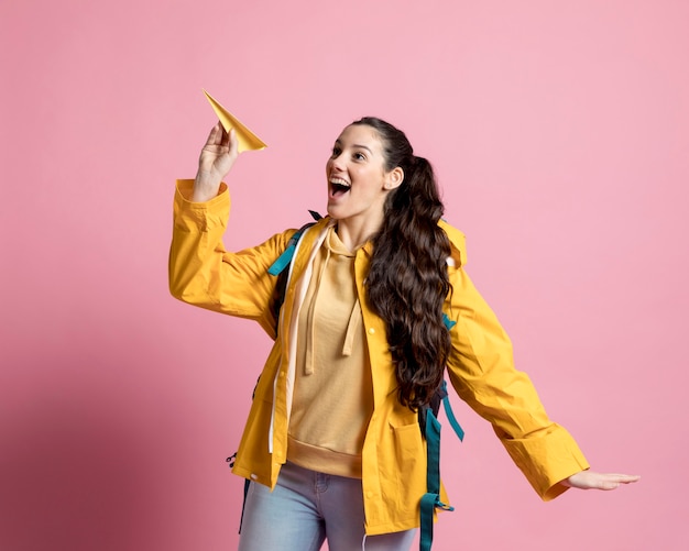 Vrouw speelt met een papier gemaakt vliegtuig