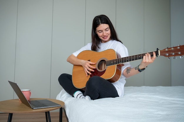 Vrouw speelt thuis gitaar tijdens quarantaine