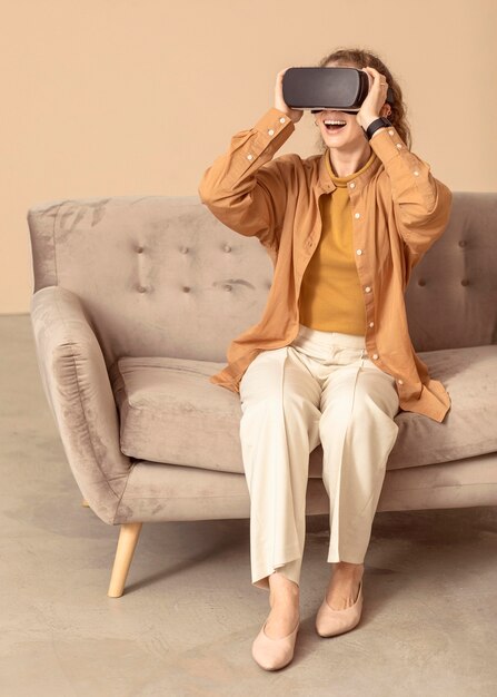 Vrouw spelen op virtual reality headset zittend op de bank