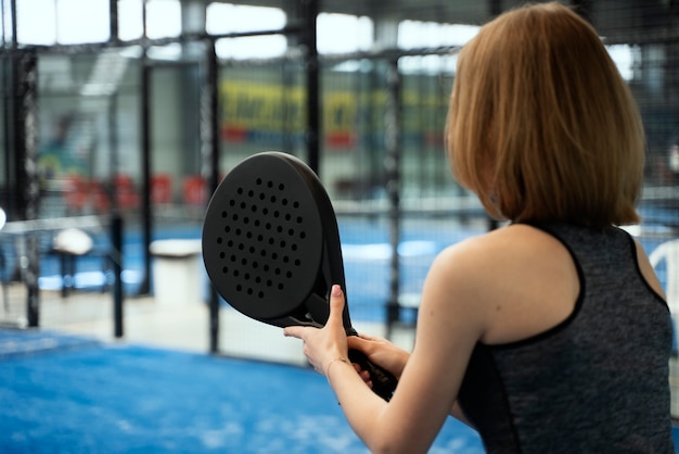 Vrouw spelen paddle tennis zijaanzicht