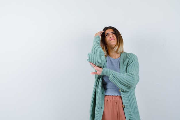 Vrouw stond in het denken pose in vrijetijdskleding en kijkt somber, vooraanzicht.