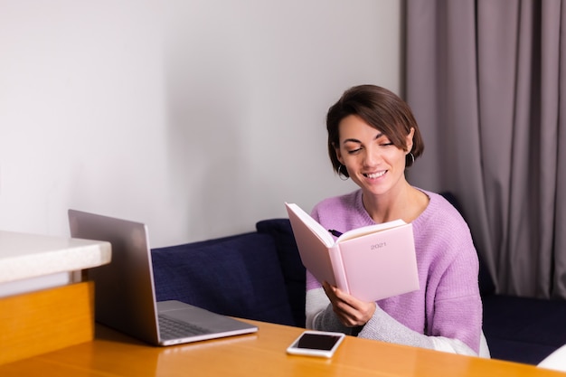 Vrouw thuis met Kladblok notebook na te denken over plannen