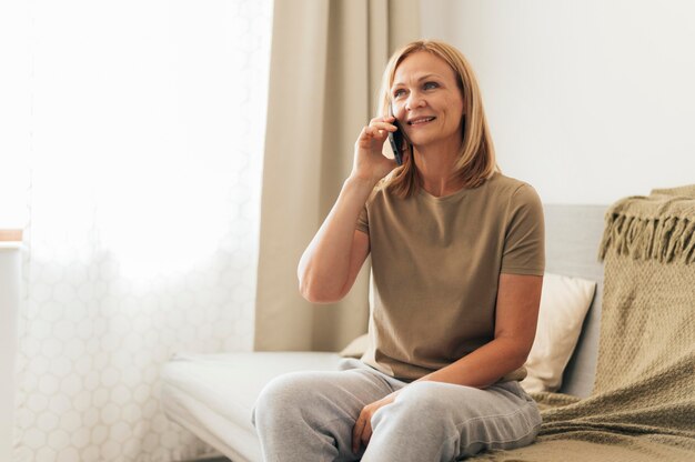 Vrouw thuis praten aan de telefoon tijdens quarantaine
