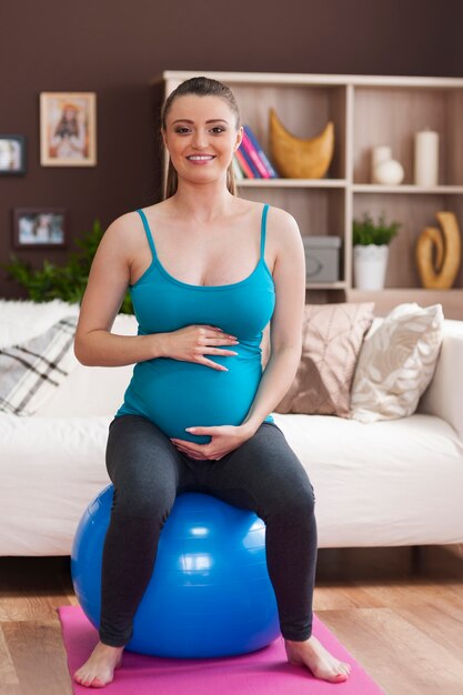 Vrouw tijdens pilates tijdens zwangerschap thuis