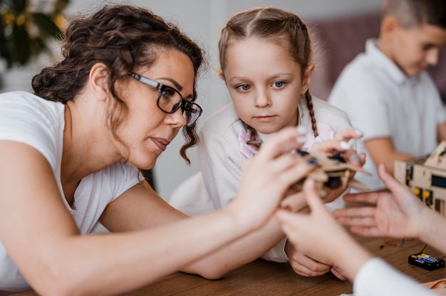 Gratis foto vrouw toont een houten controller aan haar studenten