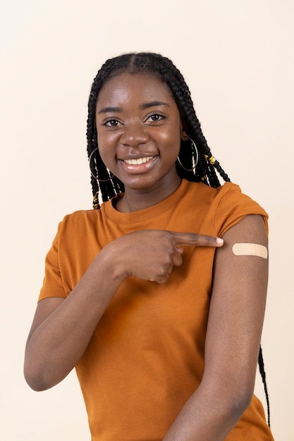 Vrouw toont sticker op arm na vaccinatie