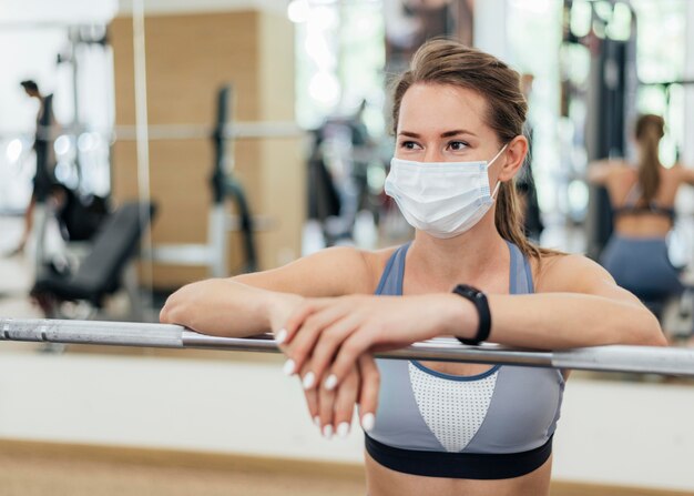 Vrouw training in de sportschool tijdens de pandemie met masker