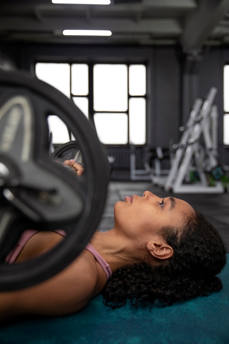 Gratis Foto vrouw training voor gewichtheffen in de sportschool