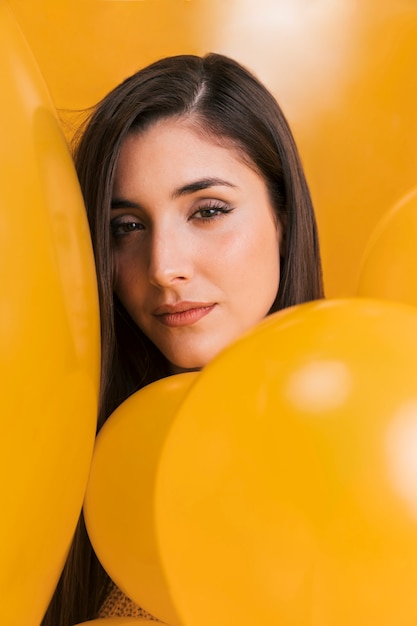 Gratis foto vrouw tussen vele gele ballonnen