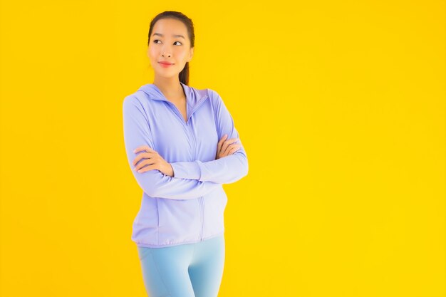 Vrouw van de portret de mooie jonge Aziatische sport klaar voor oefening op geel
