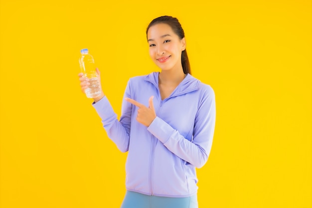 Vrouw van de portret de mooie jonge Aziatische sport klaar voor oefening op geel