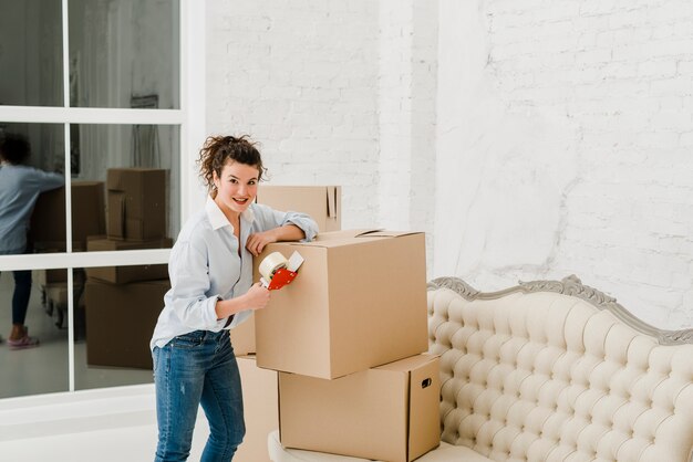 Vrouw vastmakende kleverige band aan doos