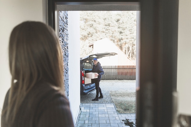 Vrouw vergadering levering man in de deuropening