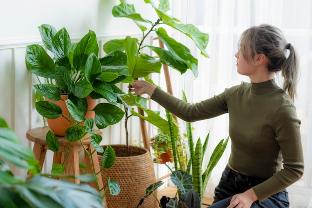 Gratis foto vrouw verzorgt en verzorgt haar plant