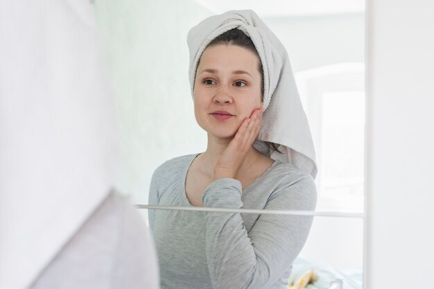 Vrouw voor spiegel in de badkamer