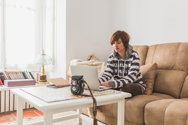 Gratis foto vrouw werken met de laptop in de woonkamer van haar huis