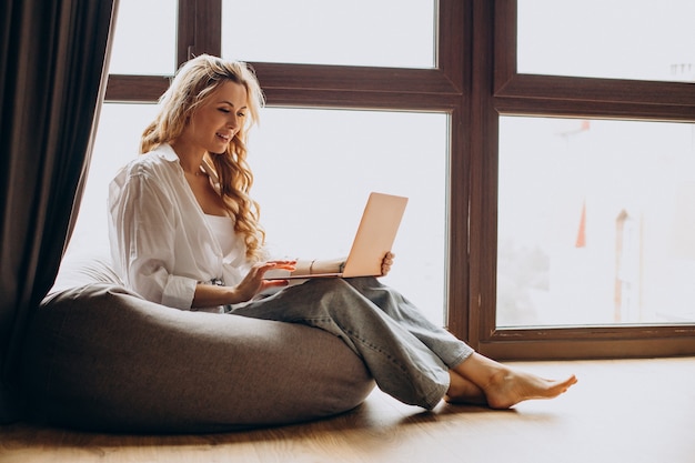 Vrouw werkt vanuit huis op laptop