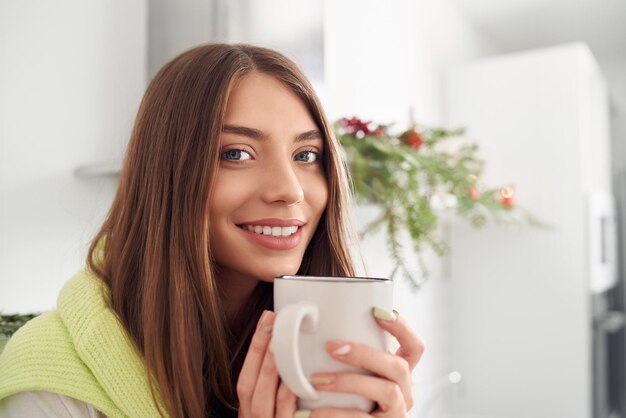 Vrouw zit en drinkt koffie met kerststemming