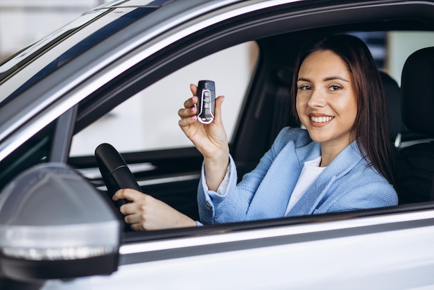 Vrouw zit in auto en houdt autosleutels vast