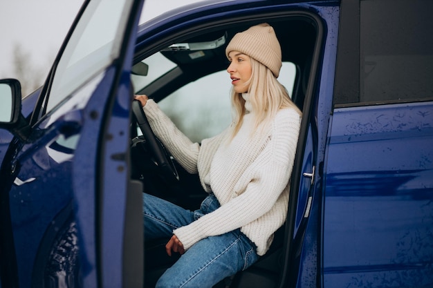 Vrouw zit in haar nieuwe auto in een winterpark