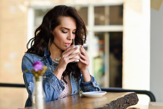 Vrouw zitten binnen in het stads cafe dragen van casual kleding