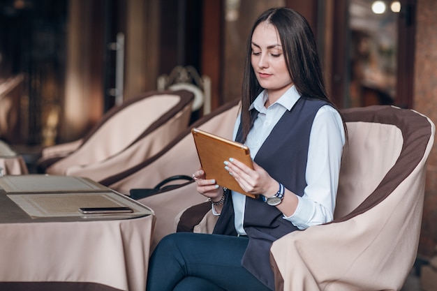 Vrouw zitten in een elegant restaurant met een tablet