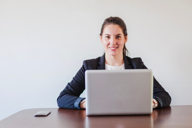Vrouw zittend aan bureau werken op laptop